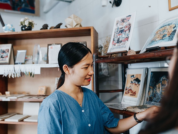 jeune vietnamienne presente produits d'estampes